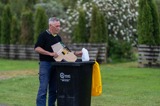 Person putting recyclable items in a recycling bin.