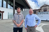 Young person and older person in front of building