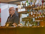 Old man behind bar at a rustic West Coast pub