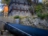 Person standing above a big water pipe