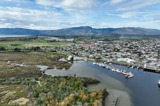 View over a town and estuary, mountains in the background.